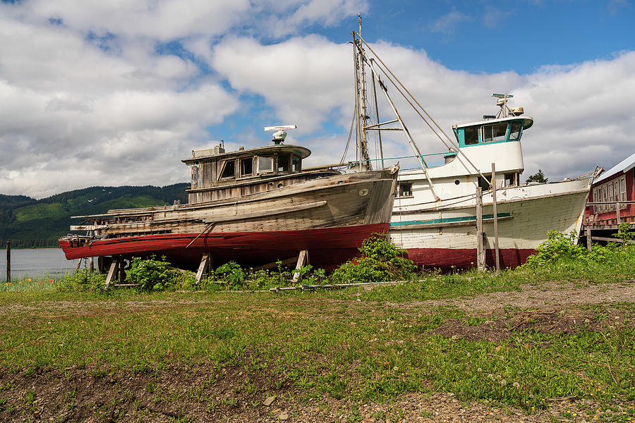 Historic but rotting fishing boats by ocean at Icy Strait Point Photograph by Steve Heap