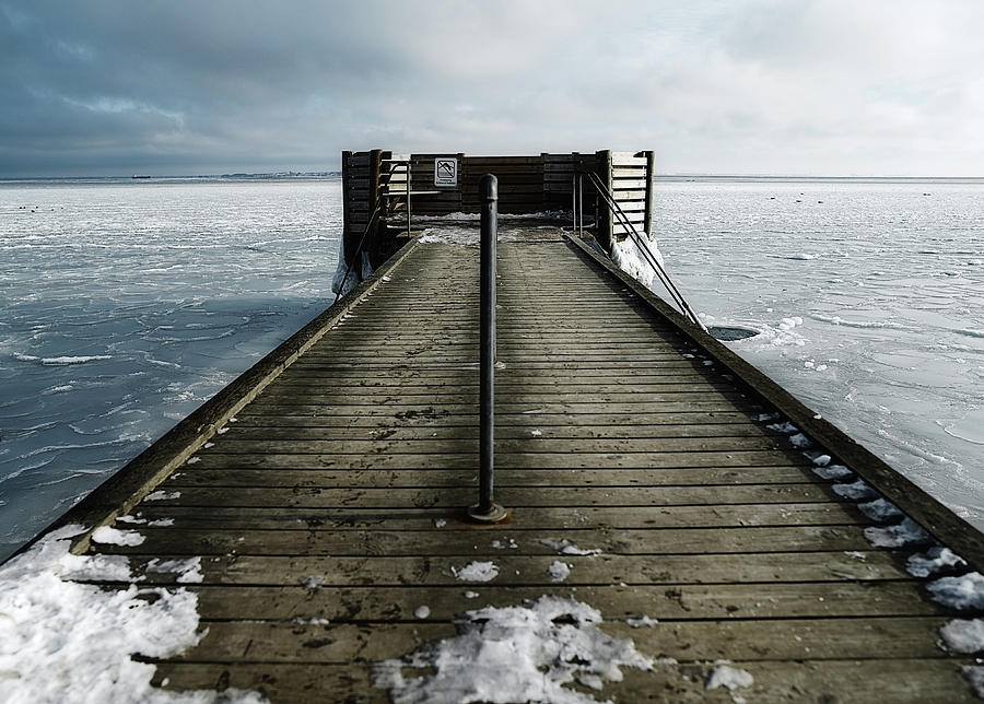 Hole in the ice for winter bathing by a jetty Photograph by David Trood