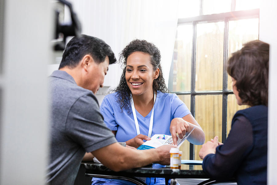 Home healthcare nurse discusses care with patient Photograph by SDI Productions