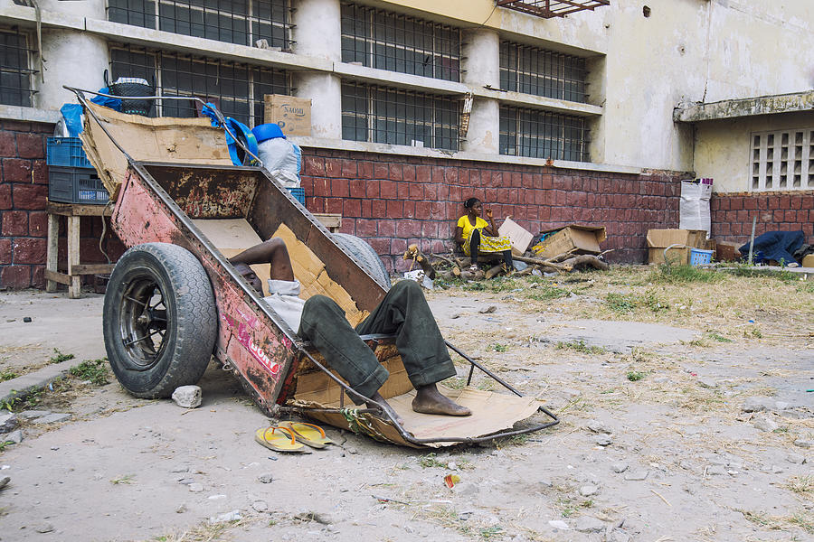 Homeless man resting in a wheelbarrow, Kinshasa, Congo Photograph by Guenterguni