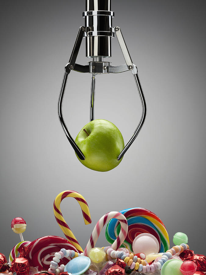 Hook with green apple above variety of sweet candies Photograph by Andy Roberts