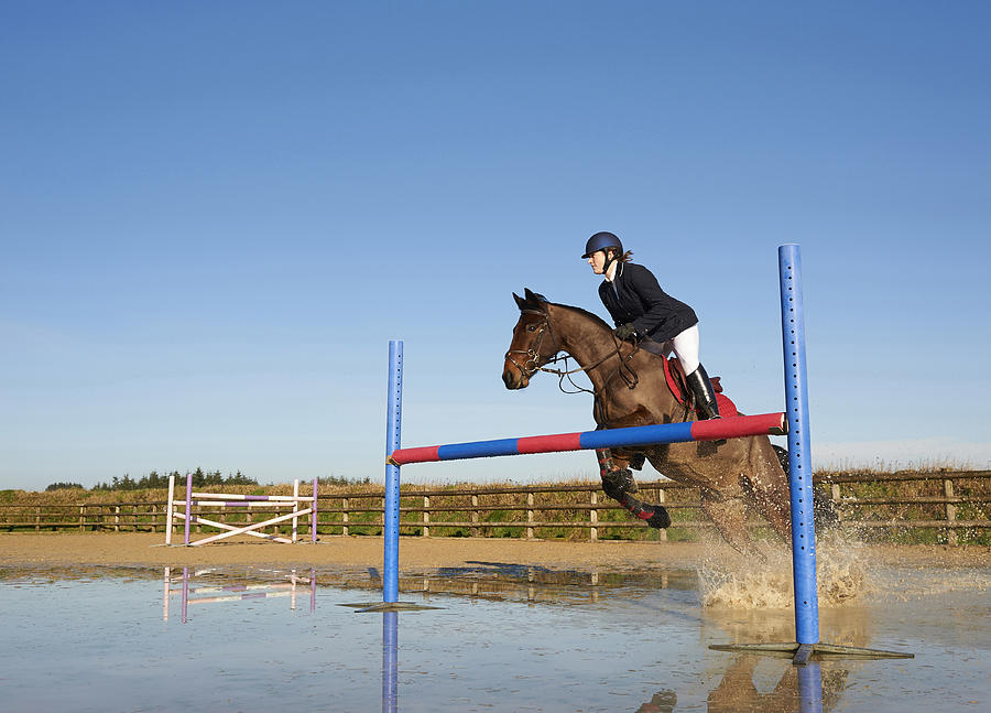 Horse and rider jumping over fence. Photograph by Dougal Waters