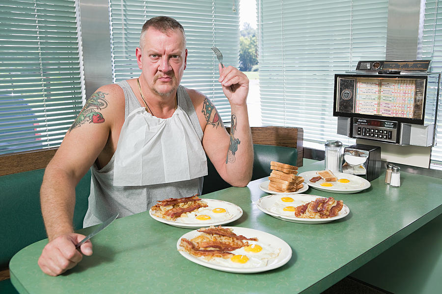 Hostile man with plates of fried food Photograph by Image Source