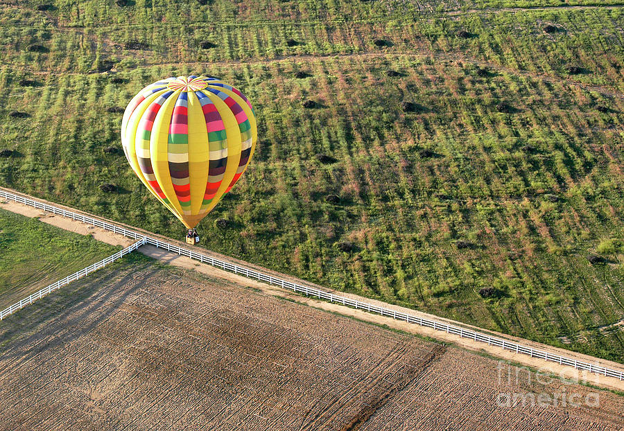 Hot air balloon flying over fields in the Temecula Valley, California.	 Photograph by Gunther Allen