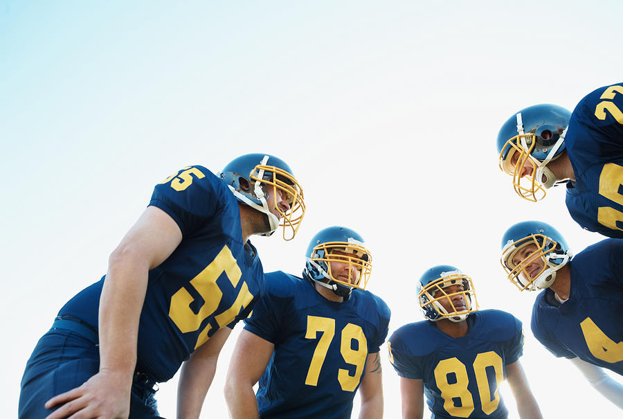 Huddle of Pro American football team against clear sky Photograph by GlobalStock