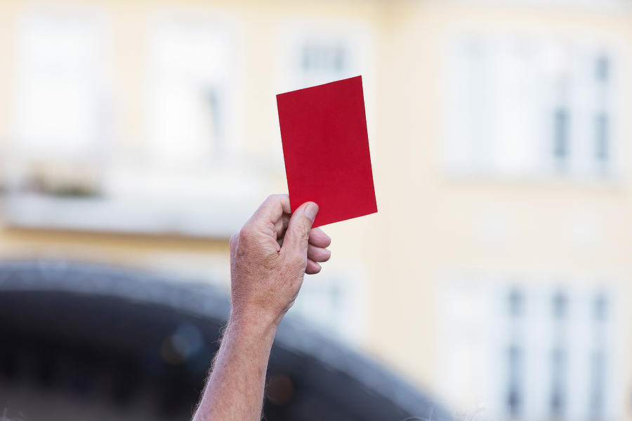 Human hand, showing red card Photograph by Fhm