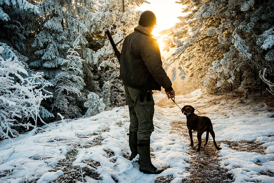 Hunter with dog in the snowy forest Photograph by Extreme-photographer