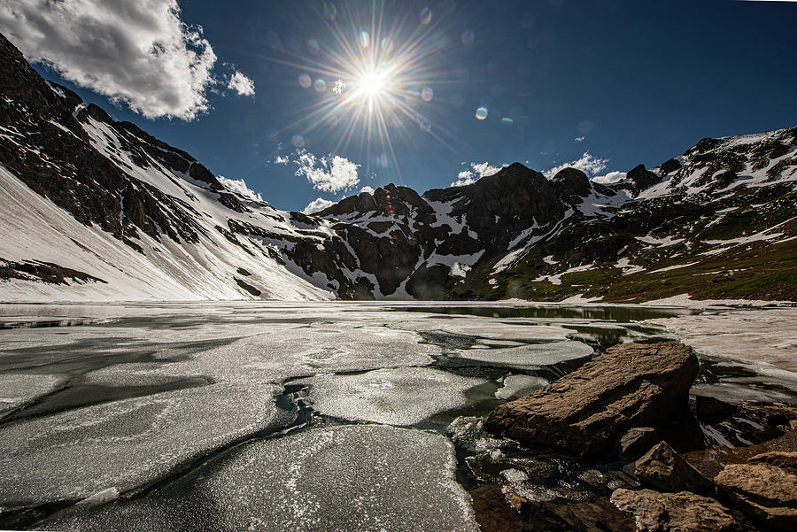 Lake in the spring with sunburst. Photograph by Greg Wyatt