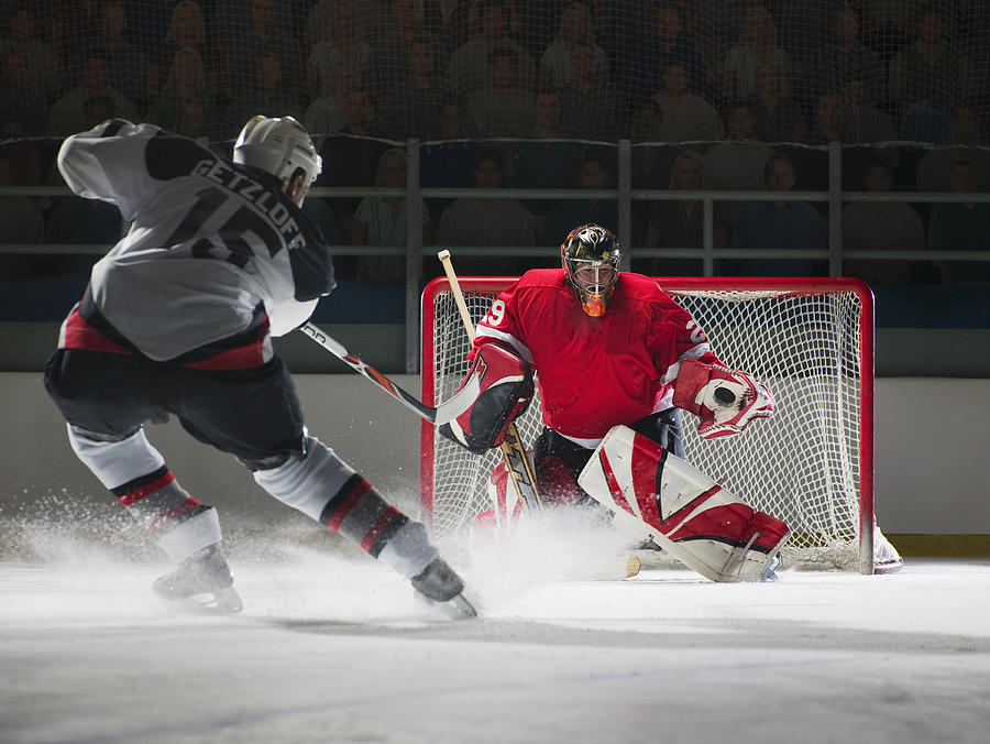 Ice hockey goalkeeper blocking a shot Photograph by Ryan McVay