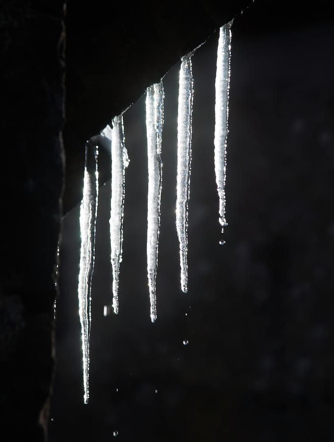 Ice stalactites glow in the sunlight Photograph by Jean-Luc Farges