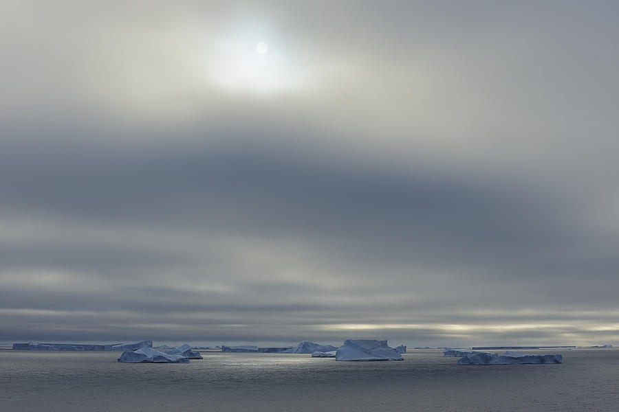 Iceberg with low-hanging clouds and sun, Antarctic Sound, Antarctic Peninsula, Antarctica Photograph by Raimund Linke