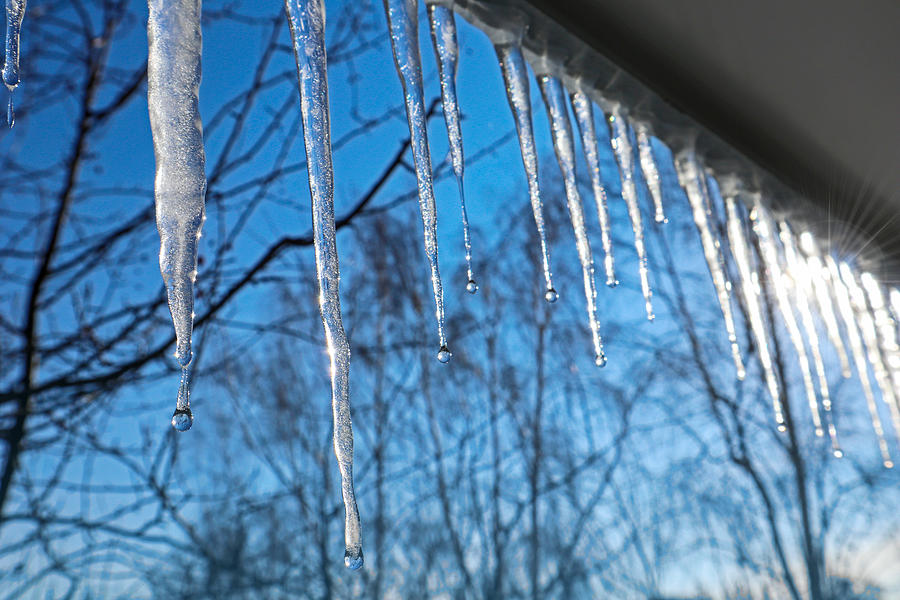 Icicles against the blue sky. Photograph by Marvod