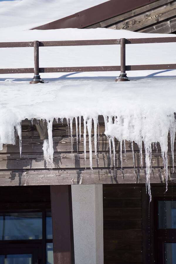 Icicles on the roof of a house Photograph by Wasja