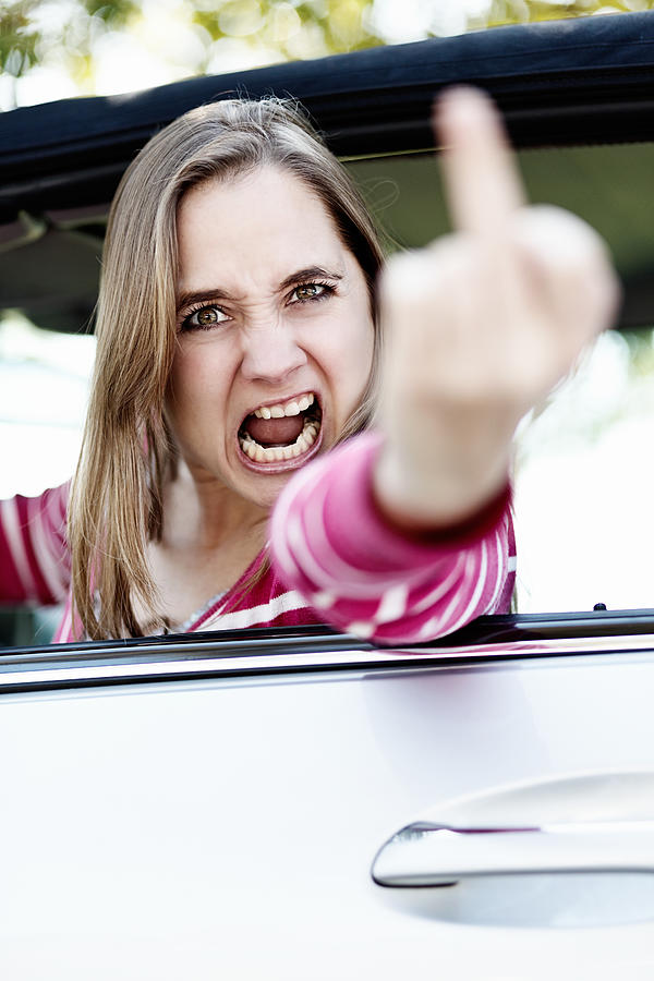 Ill get you! Furious woman driver makes obscene gesture Photograph by RapidEye
