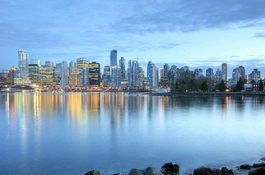 Illuminated Vancouver skyline at dusk as seen from the river Photograph by Chrisp0
