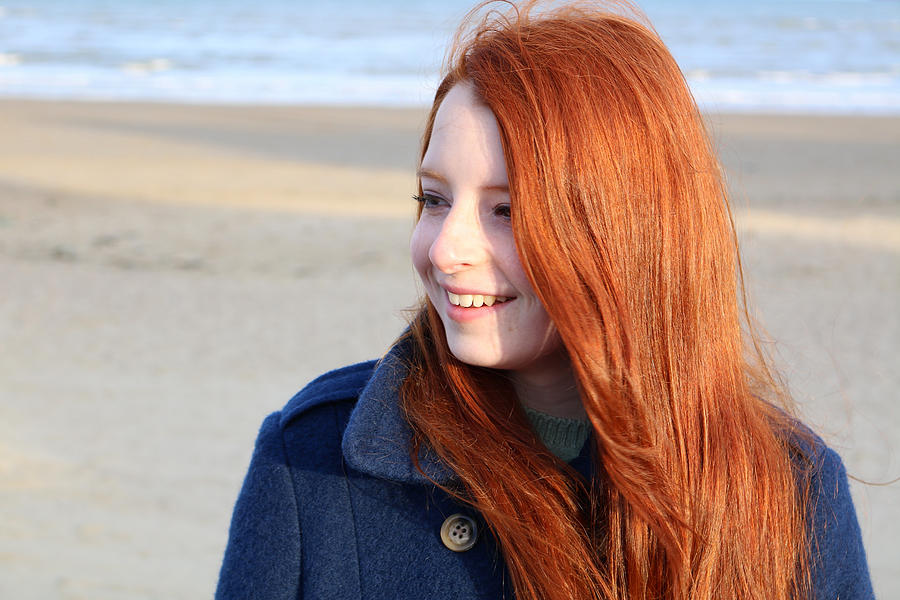 Image portrait of smiling red haired teenage girl, beach background Photograph by Mtreasure