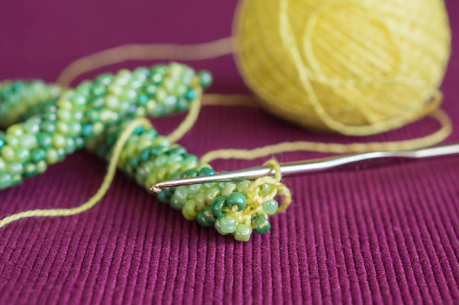 Incomplete knitted necklace from yellow and green beads Photograph by Taalulla
