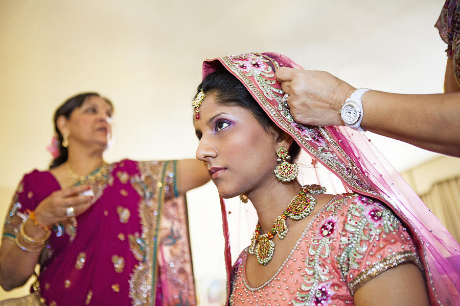 Indian bride wearing colorful fabrics and jewelry Photograph by Blend Images - Jihan Abdalla