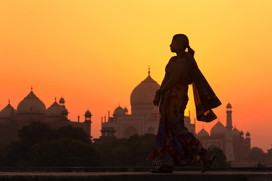 Indian woman walking at sunset near Taj Mahal Photograph by Adrian Pope