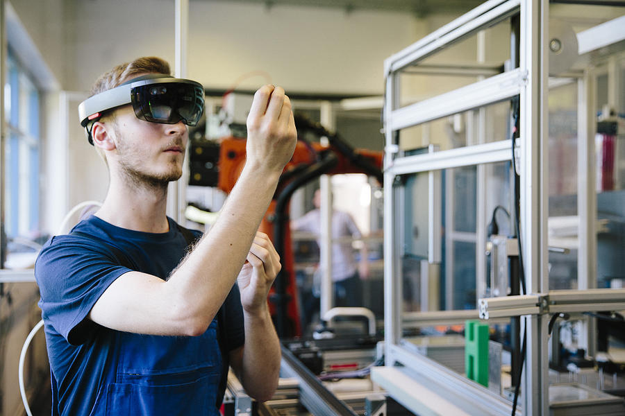 industry 4.0: Young engineer works with a head-mounted display Photograph by Fotografixx