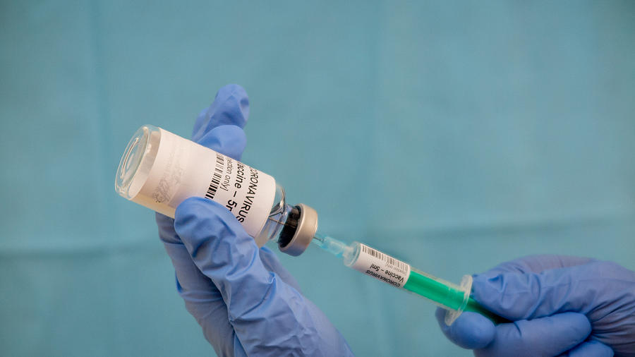 Infectious doctor fills injection syringe with CO-VID 19 vaccine - concept,  for prevention, immunization and treatment  for new corona virus infection(COVID-19,novel coronavirus disease 2019) Photograph by Paul Biris
