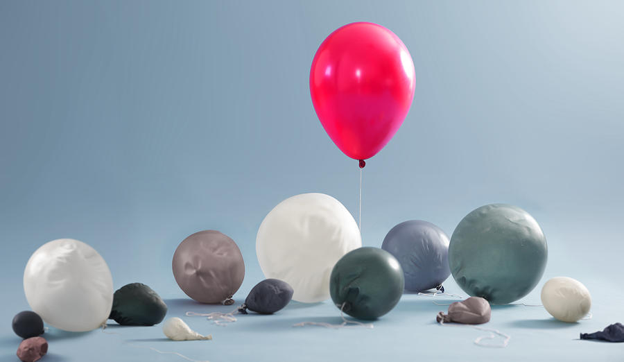 Inflated balloon surrounded by deflated balloons Photograph by Peter Cade Inflated balloon surrounded by deflated balloons Photograph by Peter Cade
