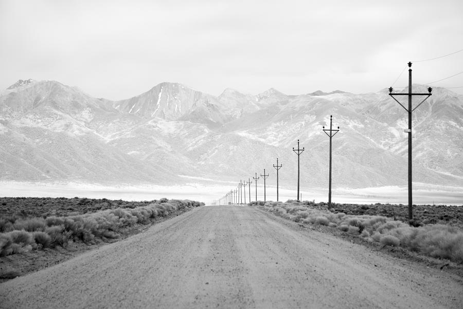 Infrared long exposure of a lone road and power lines leading into the San Juan Mountain Range. Photograph by Jon Paciaroni