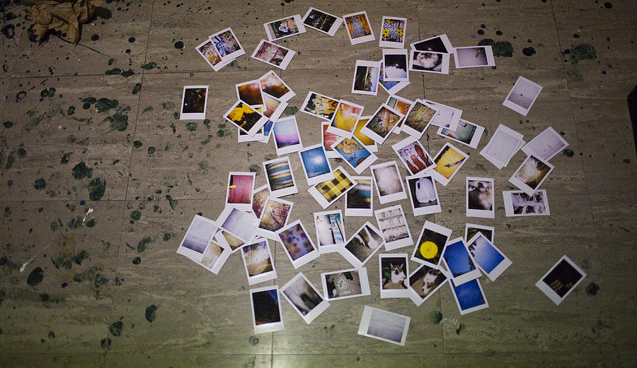 Instant photographs scattered Photograph by Sarah Palmer