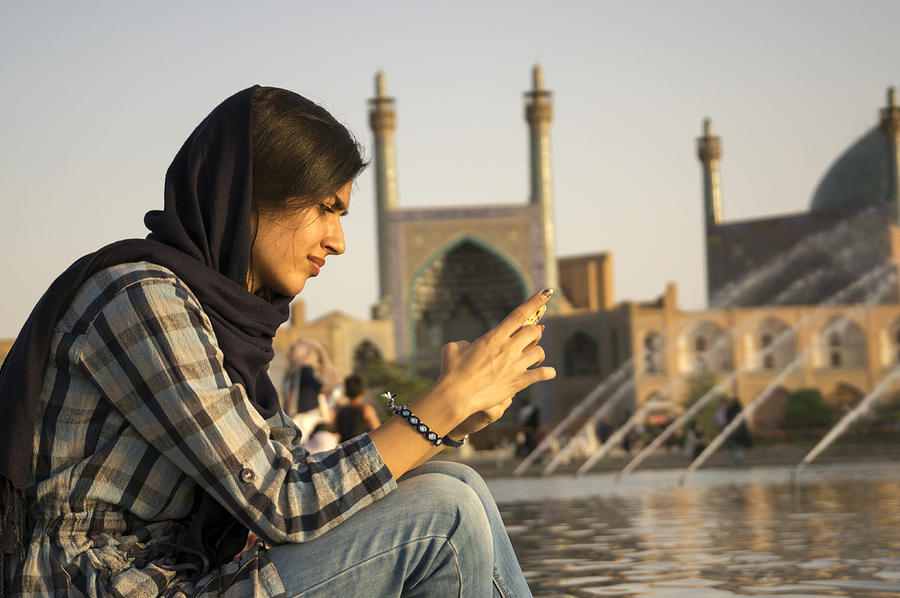 Iranian woman checking her mobile phone Photograph by Suc