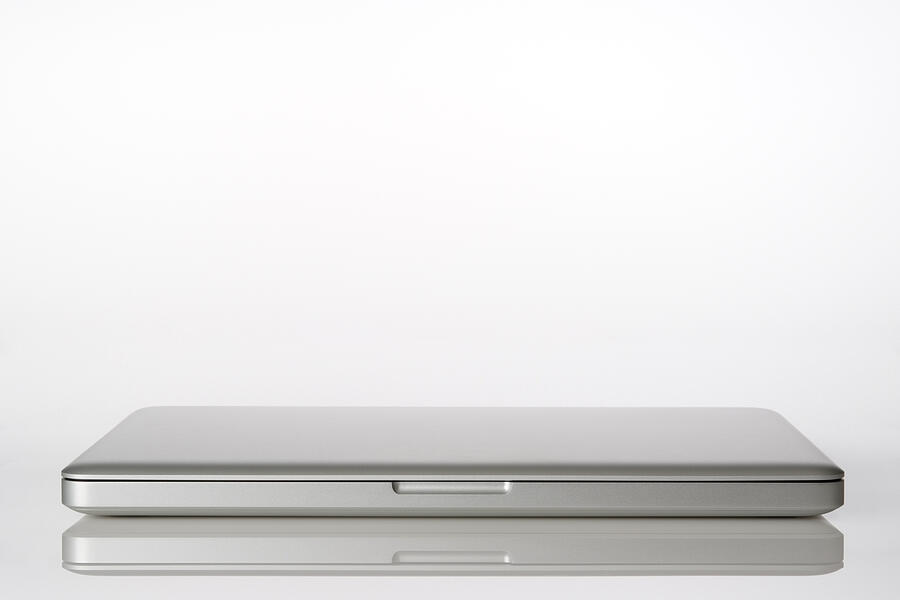 Isolated shot of closed laptop on white background Photograph by Kyoshino