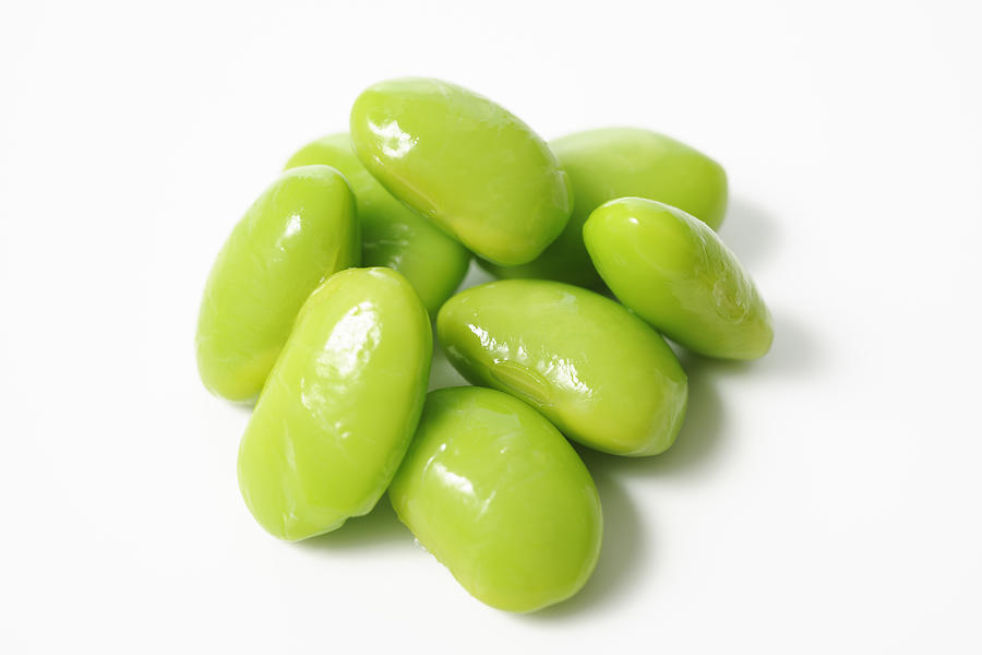 Isolated shot of stacked boiled green soybeans on white background Photograph by Kyoshino