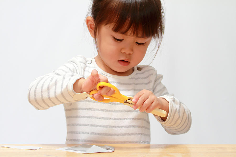 Japanese girl cutting paper with scissors (3 years old) Photograph by Ziggy_mars