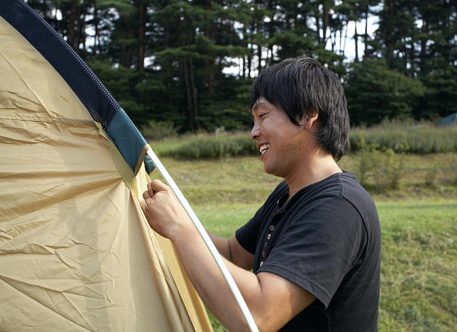 Japanese man preparing a camping tent Photograph by Seiya Kawamoto