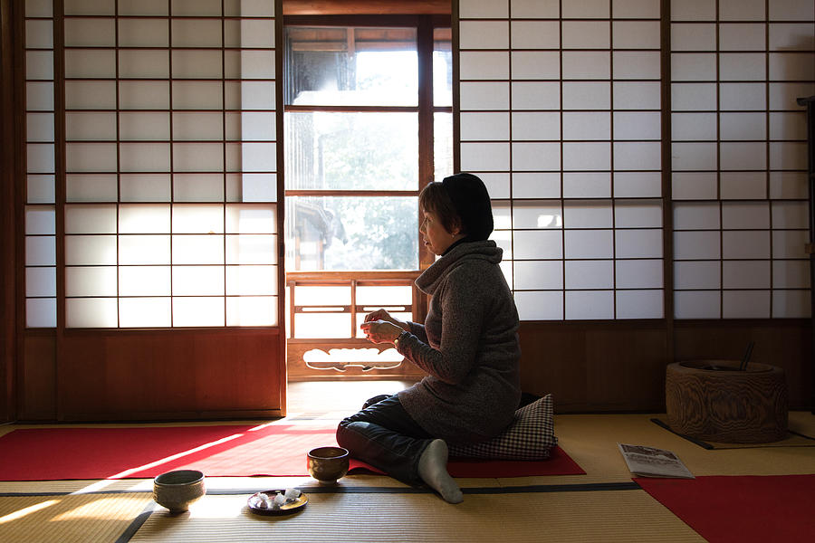 Japanese woman drinking matcha in traditional room Photograph by Kumikomini