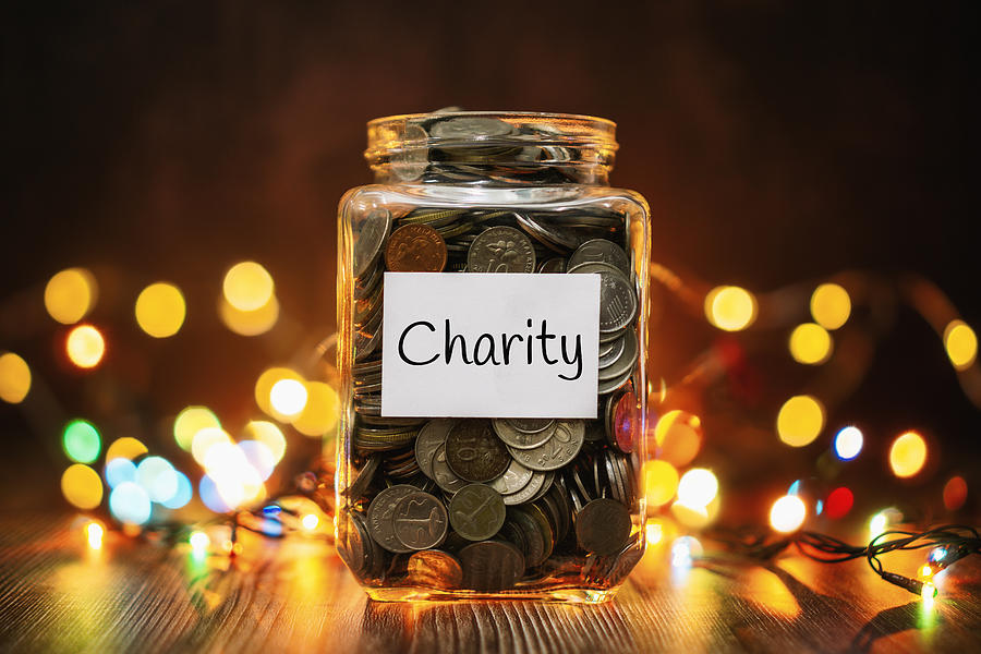 Jar of Coins for Charity Against Christmas Lights Background Photograph by Constantine Johnny