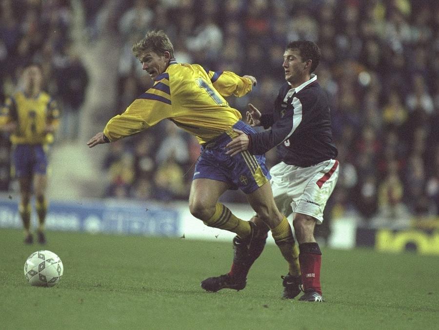 Jesper Blomqvist of Sweden is held back by Billy McKinlay of Scotland Photograph by David Rogers