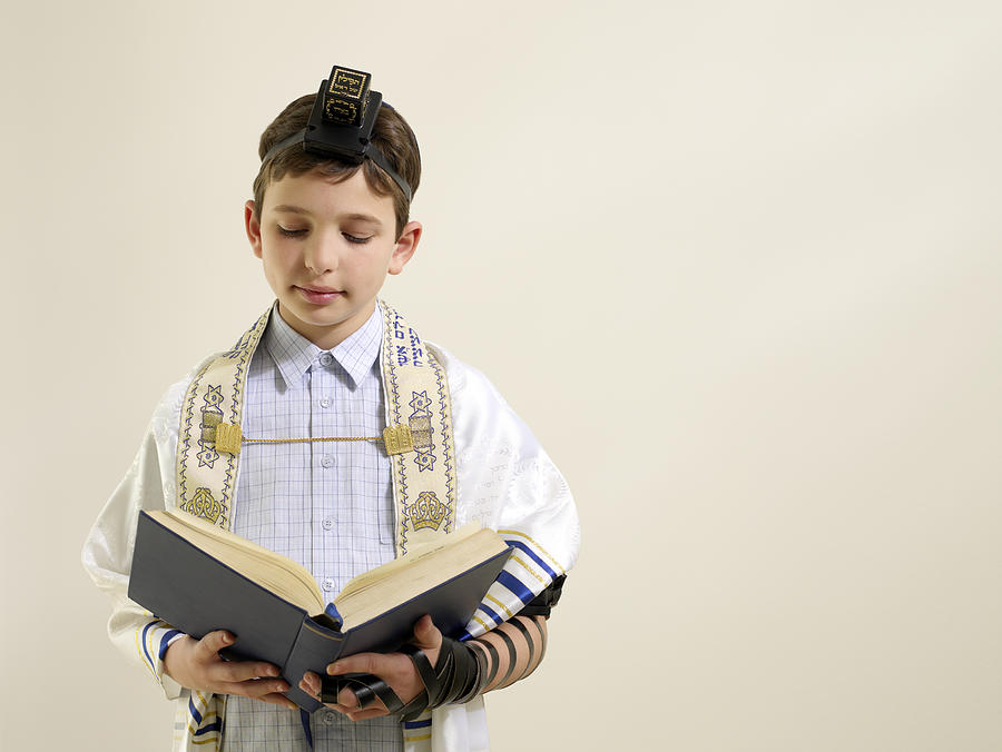 Jewish boy reading from siddur Photograph by Image Source