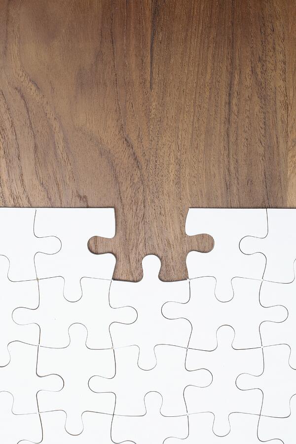 Jigsaw puzzle on wooden background, piece missing Photograph by Amana Productions Inc