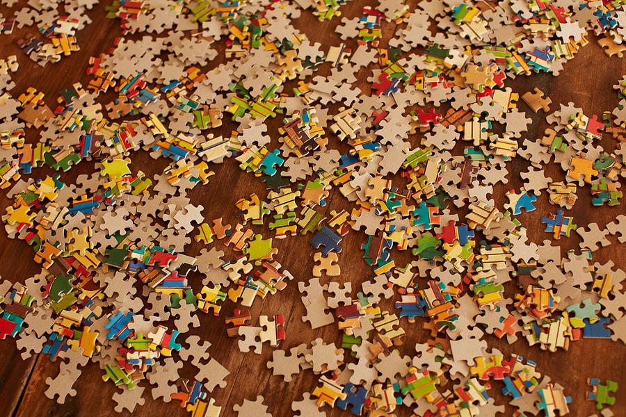 Jigsaw puzzle pieces on wooden floor Photograph by Heshphoto