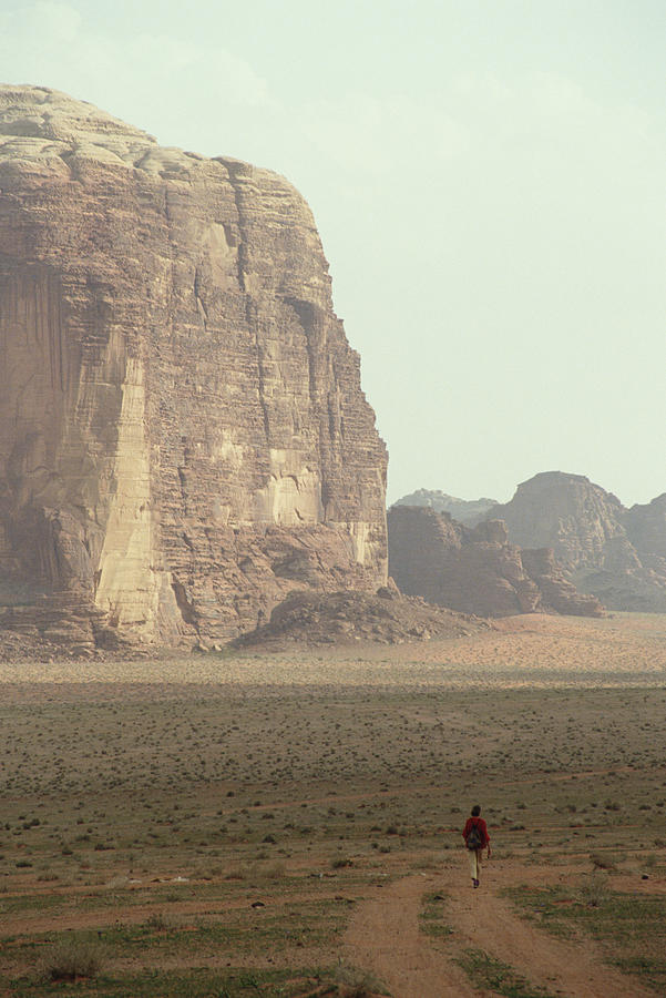 Jordan, Aqaba, Wadi Rum, woman hiking on desert track, rear view Photograph by Sami Sarkis