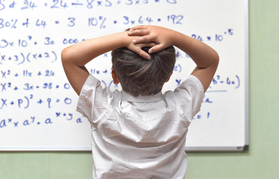 Junior Pupil Amazed By Maths On Classroom Whiteboard Photograph by Peter Dazeley