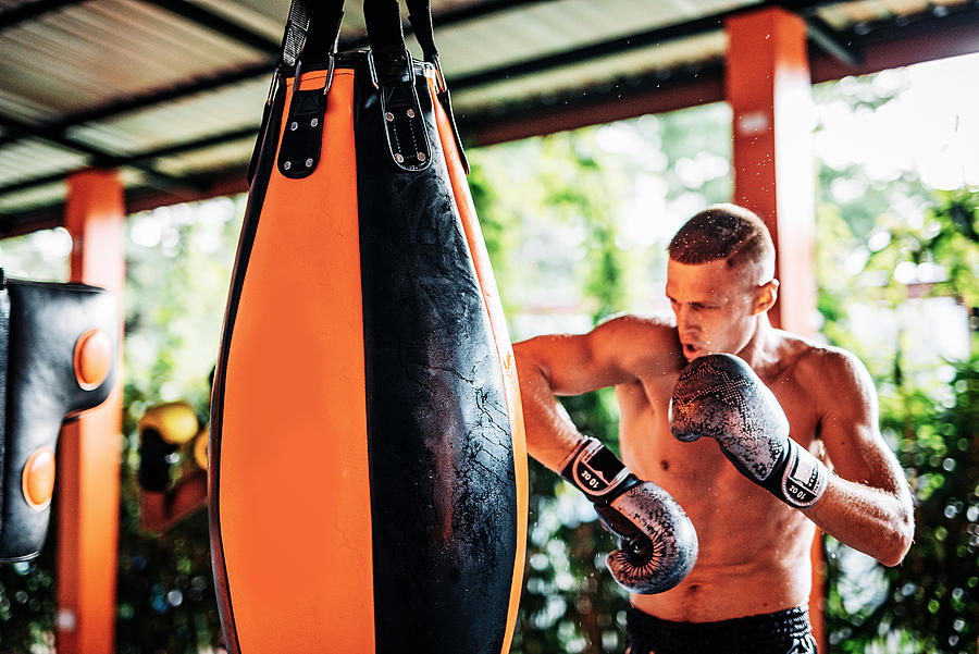 Kickboxing champion training with punching bag Photograph by Drazen_