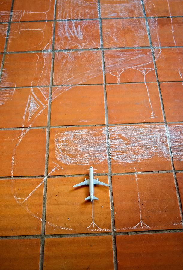 Kids game representing an airport, with small airplanes on a tiled floor Photograph by Juan Camilo Bernal
