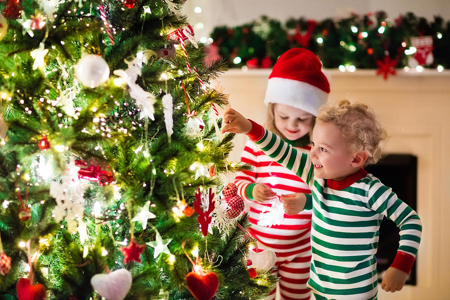 Kids in red and green striped pajamas under Christmas tree Photograph by FamVeld