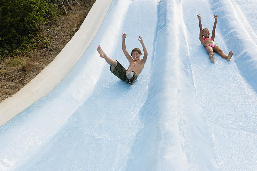 Kids on a water slide Photograph by Image Source