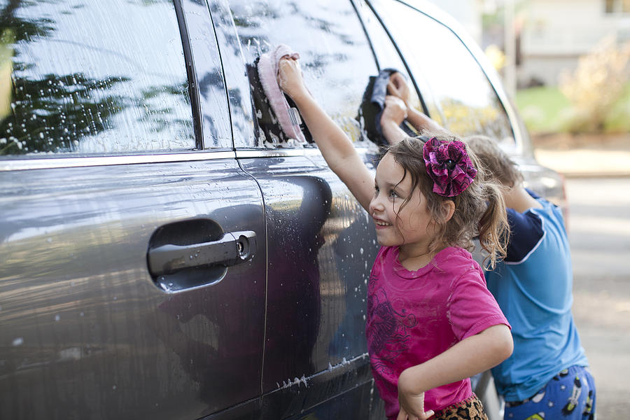 Kids washing the car Photograph by AE Pictures Inc.
