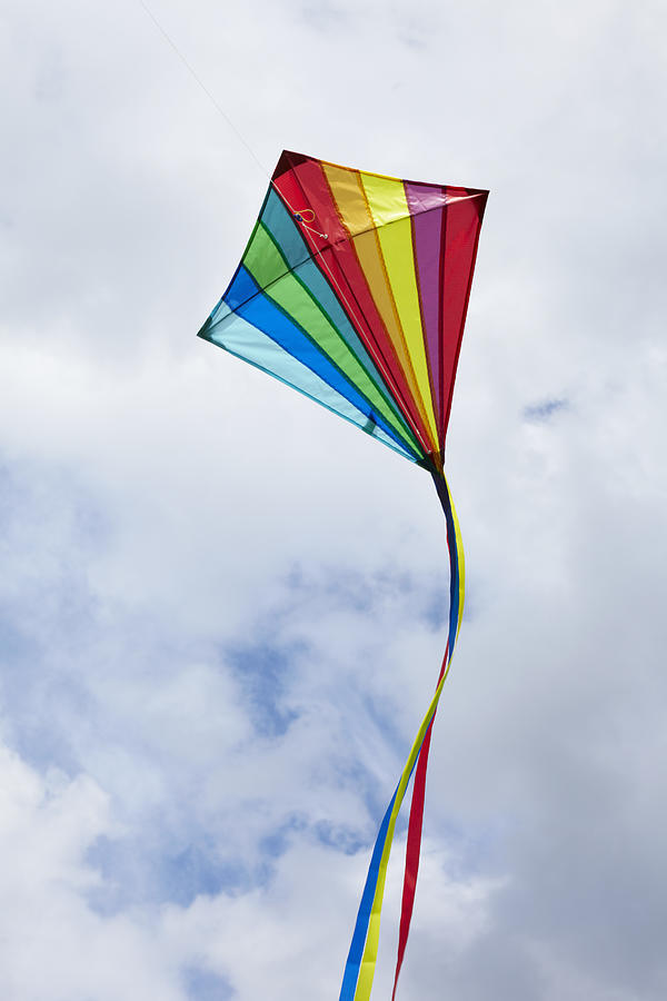 Kite flying in cloudy sky Photograph by Tim Hall