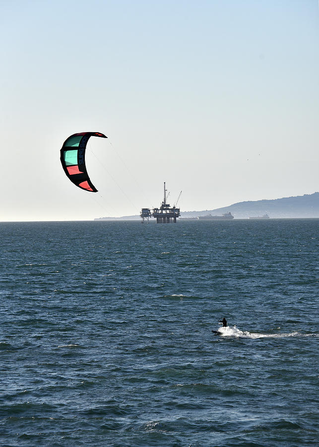 Kite surfing near an offshore oil platform sseascape Photograph by Mark Stout
