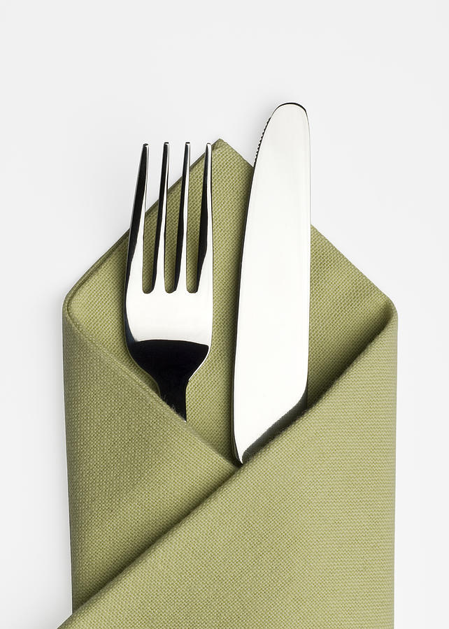 Knife and fork in a green napkin Photograph by P1images