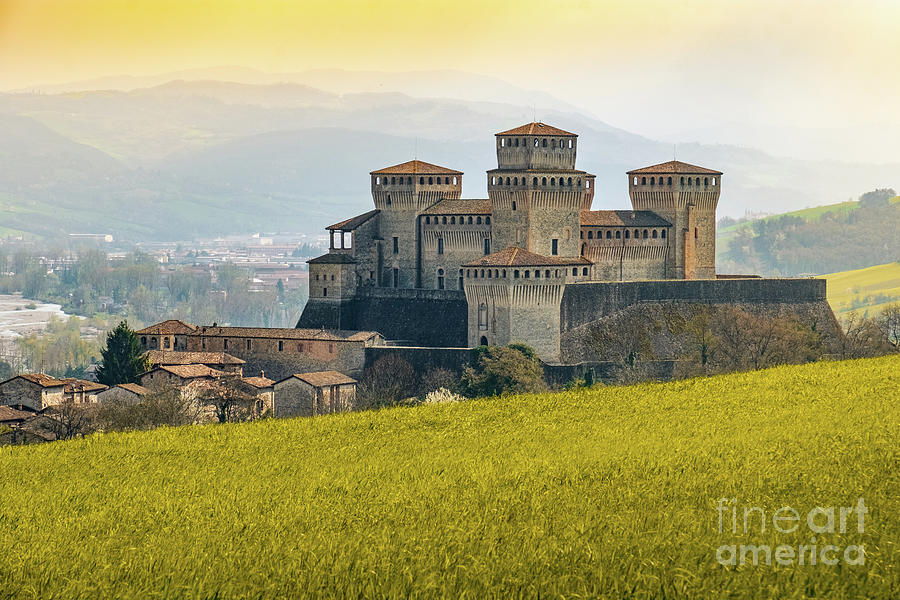 landmarks of italy, the Torrechiara fantasy castle near Parma - Italy with yellow warm toned grass a Photograph by Luca Lorenzelli